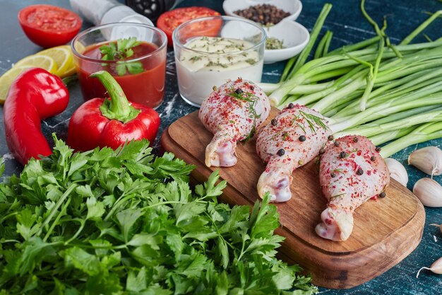 Raw chicken legs on a wooden board.