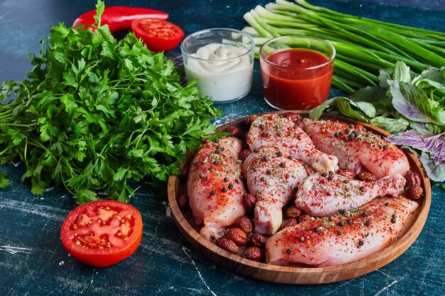 Raw chicken pieces with herbs and spices.