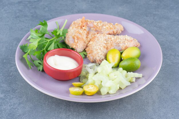 Raw chicken wing nuggets on purple plate.