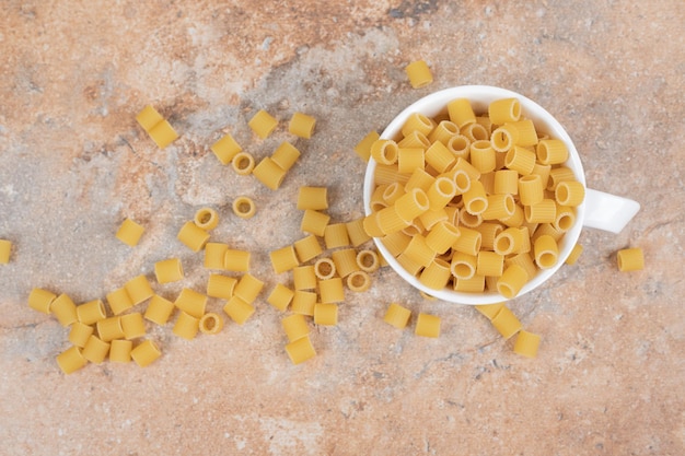 Raw delicious macaroni on white cup. 