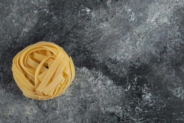 Raw dry nest noodles on a marble table . 