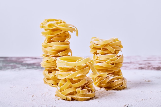 Free photo raw fettuccine on grey surface.