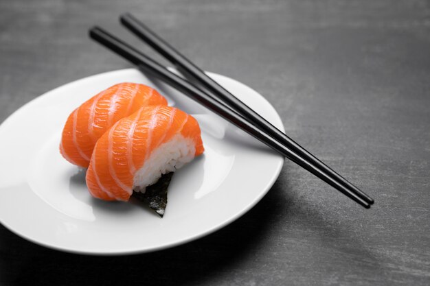 Raw fish on plate with sticks high angle