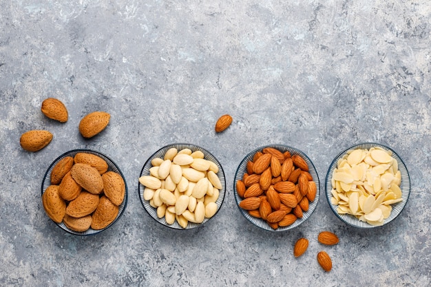 Free photo raw fresh almonds with shell, without shelll, almond slices, top view