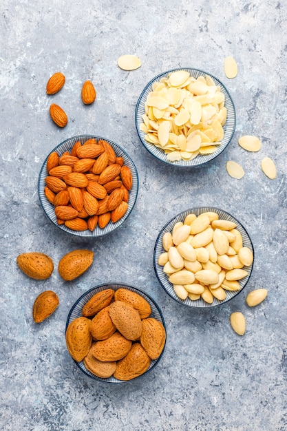 Raw fresh almonds with shell, without shelll, almond slices, top view