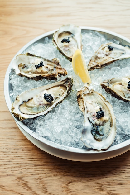 Free Photo raw and fresh oyster with caviar on top and lemon