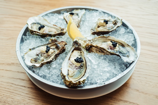 Raw and fresh Oyster with caviar on top and lemon