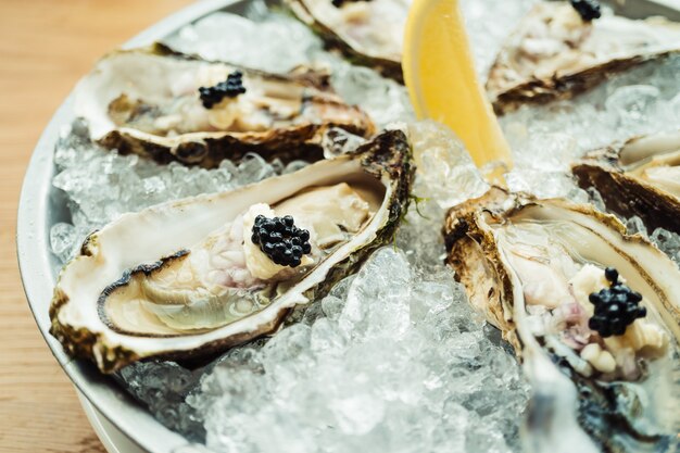 Raw and fresh Oyster with caviar on top and lemon