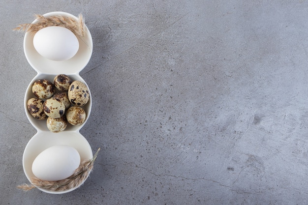 Free photo raw fresh quail eggs placed on a stone background.