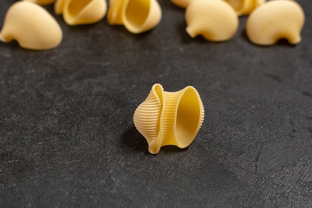 raw italian pasta yellow colored little formed on dark