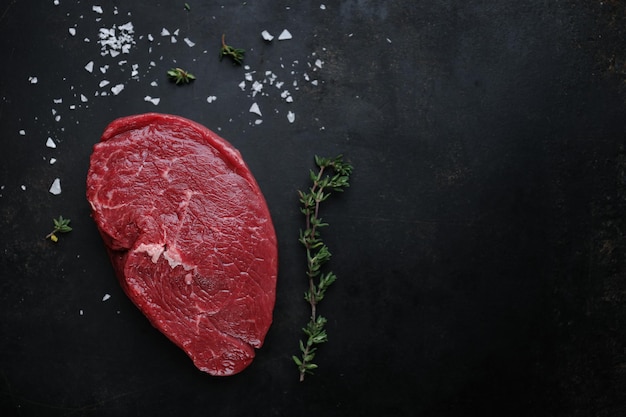 Raw meat with spices and herbs on table