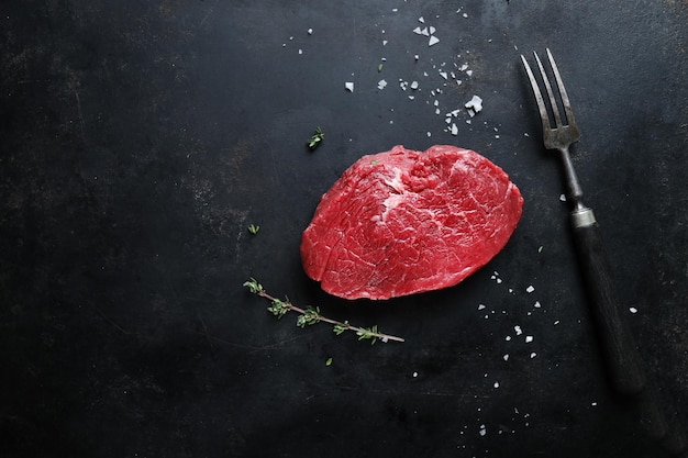 Raw meat with spices and herbs on table