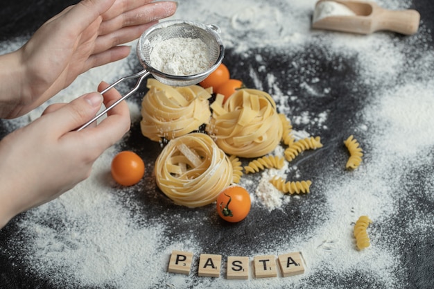 Raw nest noodles with flour on black.