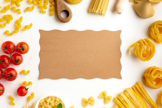 Raw pasta assortment and tomatoes with cardboard mock-up