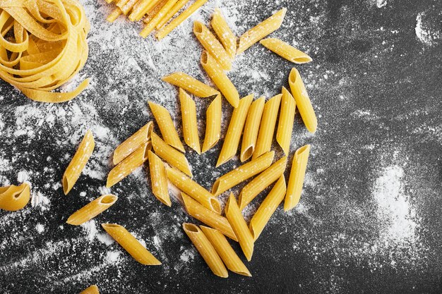 Raw pasta on a flour covered surface.