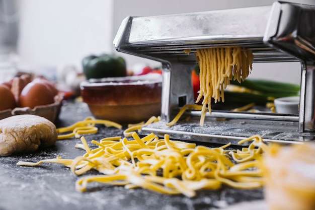 Raw pasta lying near machine