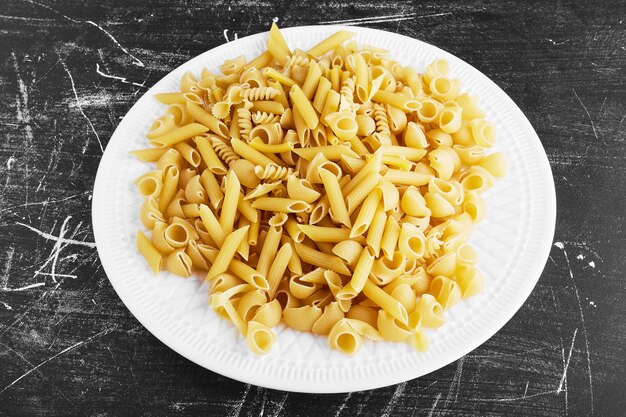 Raw pasta in a white plate.