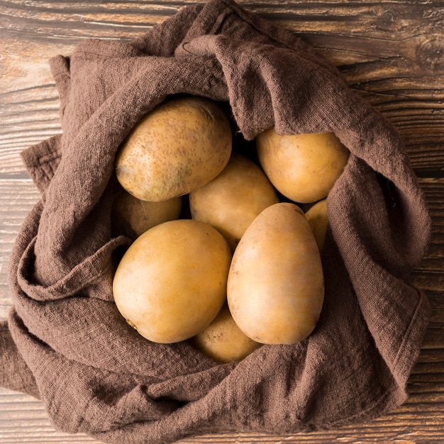 Raw potatoes on brown cloth