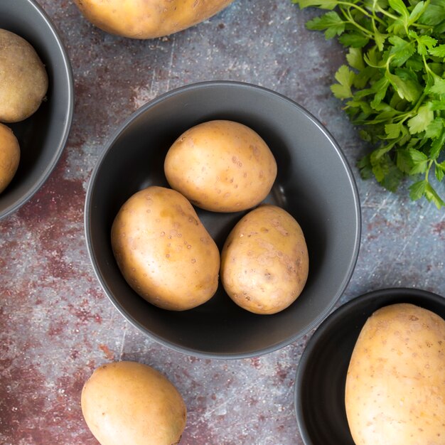 Raw potatoes in gray bowl