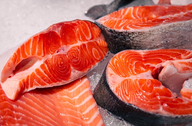 Raw salmon pieces of fish closeup on the showcase of a seafood store