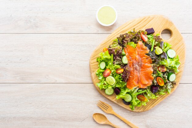 Raw Smoked salmon meat fish with fresh green vegetable salad