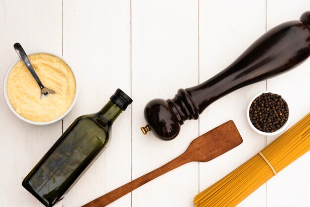 Raw spaghetti pasta and it's ingredient with kitchen utensil on white table