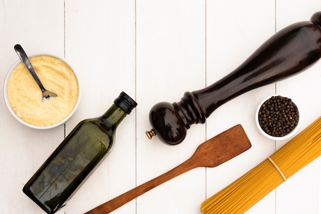 Raw spaghetti pasta and it's ingredient with kitchen utensil on white table