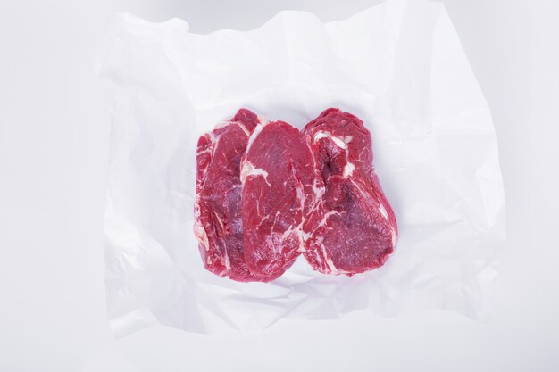 Raw steak on white paper