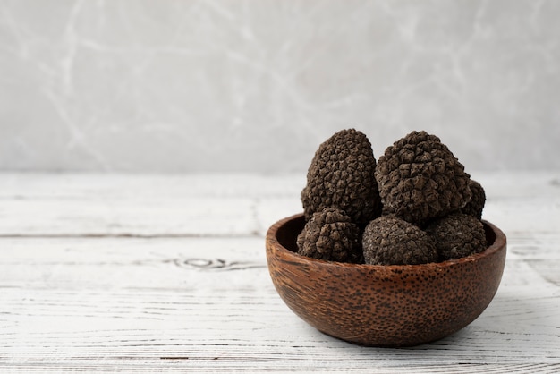 Raw truffles in bowl on wooden table