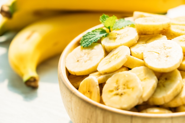 Free photo raw yellow banana slices in wooden bowl