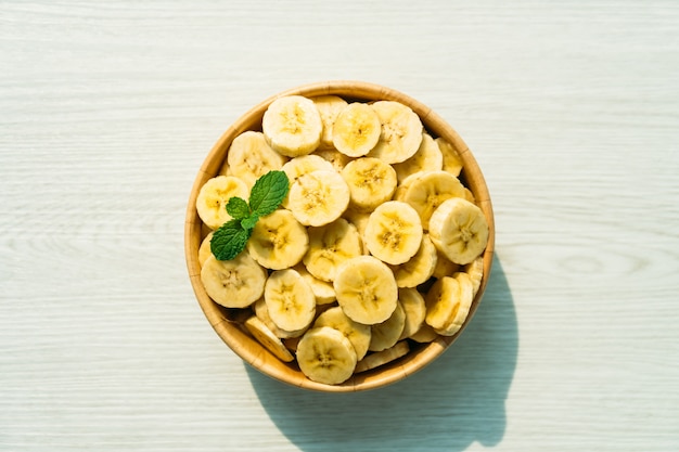 Free photo raw yellow banana slices in wooden bowl