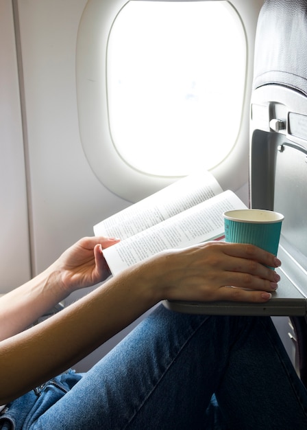 Free photo reading a book and holding a cup