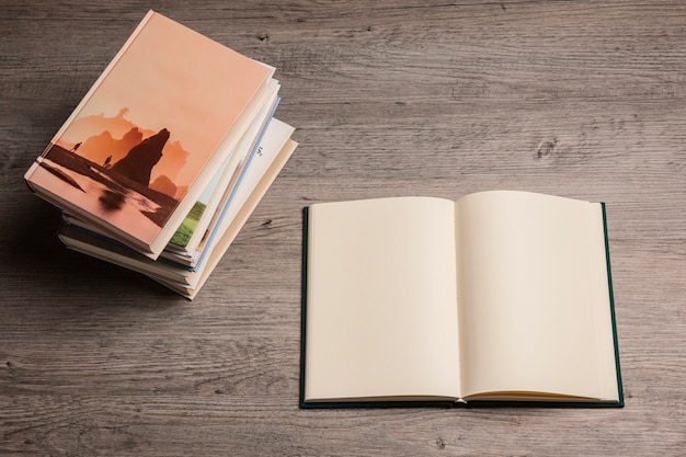 Reading concept with open book next to pile of books