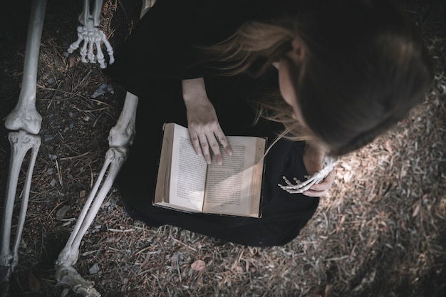 Reading lady in dark clothes near bones