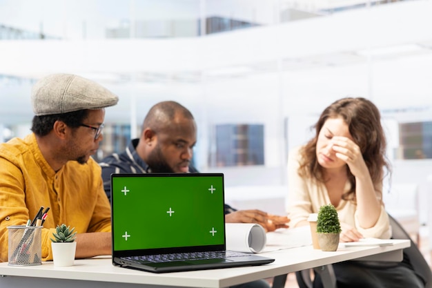 Free photo real estate agents and client examine blueprints next to a green screen