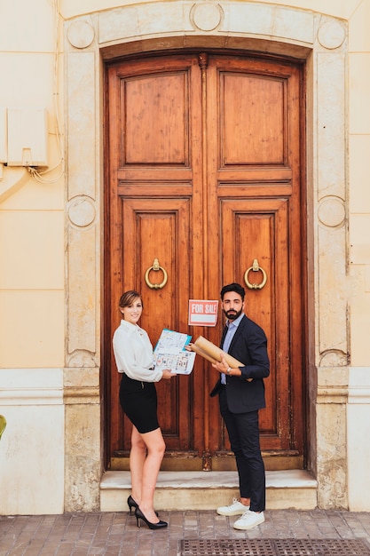 Free photo real estate agents posing at the main door