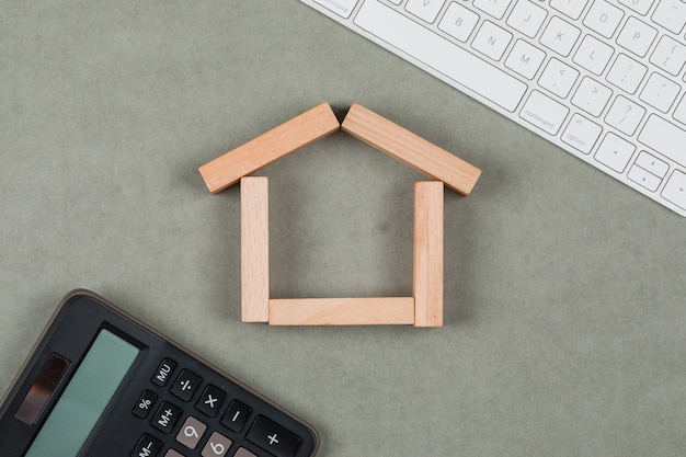 Free Photo real estate concept with wooden blocks, calculator, keyboard on grey background flat lay.