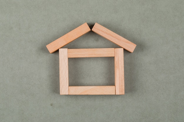 Free photo real estate concept with wooden blocks on grey background flat lay.