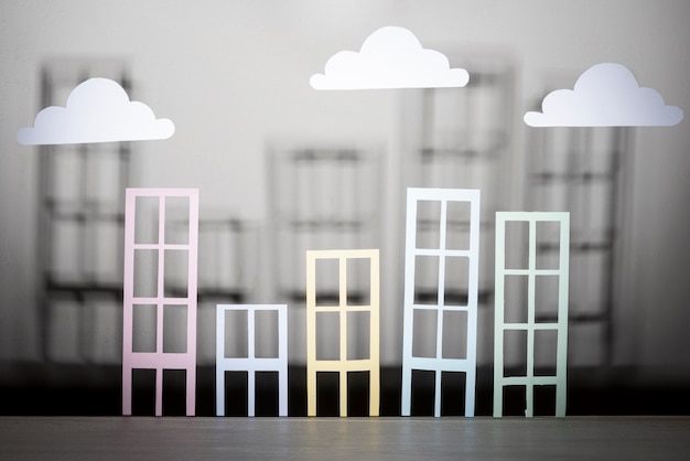 Free photo real estate design with paper buildings and clouds