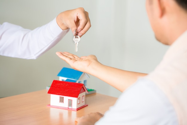 Free photo real estate sales manager giving keys to customer after signing rental lease contract of sale purchase agreement