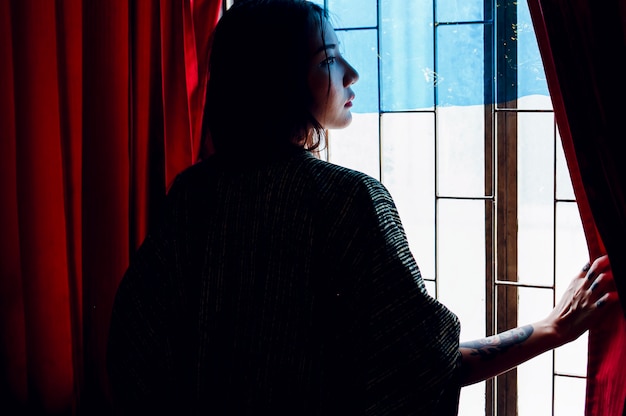 Free Photo rear view of asian woman standing by the window