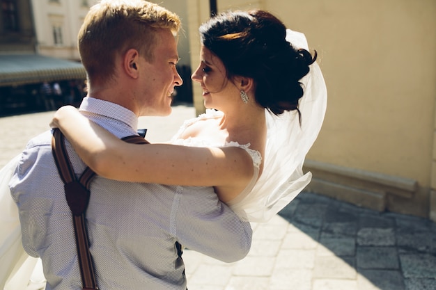 Free photo rear view of bride in the groom's arms