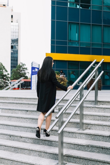 Rear view of a businesswoman climbing staircase