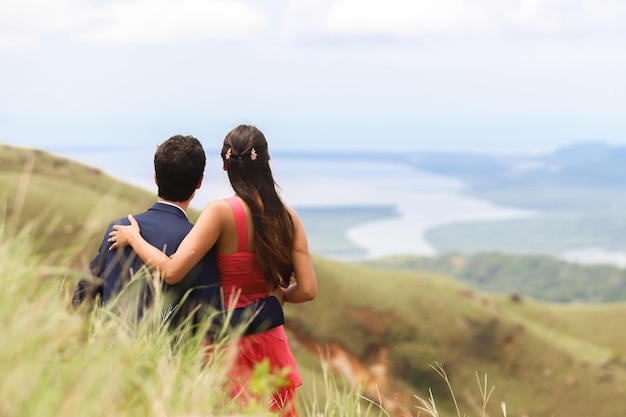 Rear view of a couple in their engagement day looking at the beautiful landscape