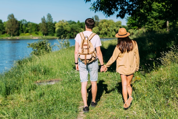 Rear view of couple walking near the lake