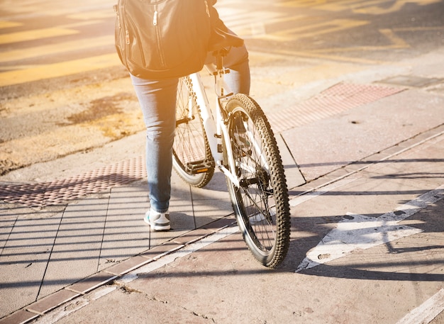 Rear view of a cyclist with backpack waiting on road