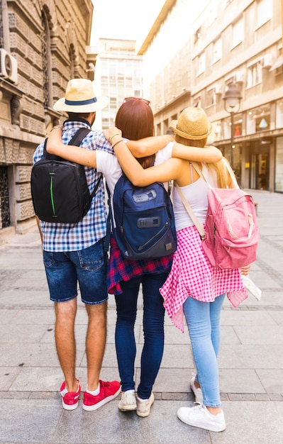 Rear view of friends standing on street