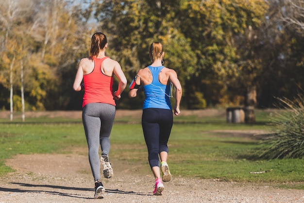 Rear view of healthy sportswomen running outdoors