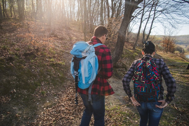 Rear view of hikers with backpacks walking