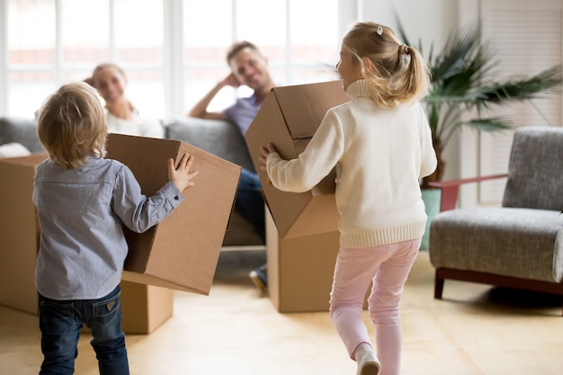 Free photo rear view at kids playing with boxes on moving day